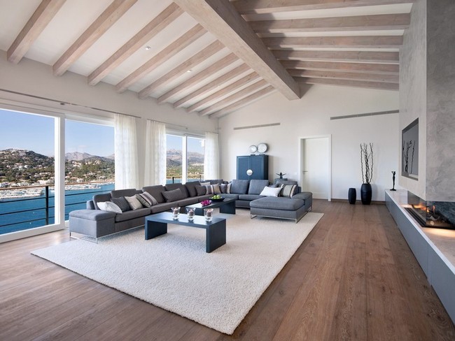 Modern nappali látszó gerendákkal és egyszínű szőnyeggel