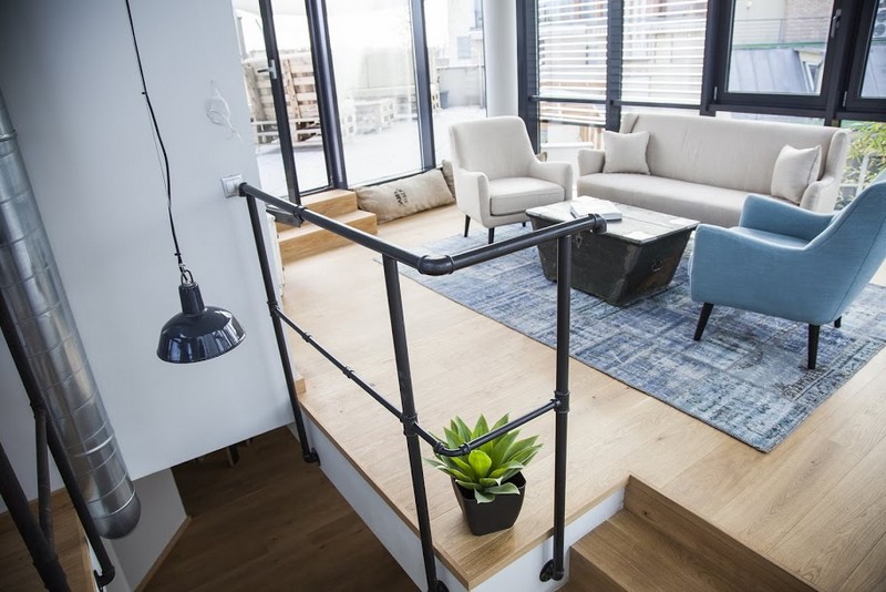 Modern átalakított nappali világos fotelekkel