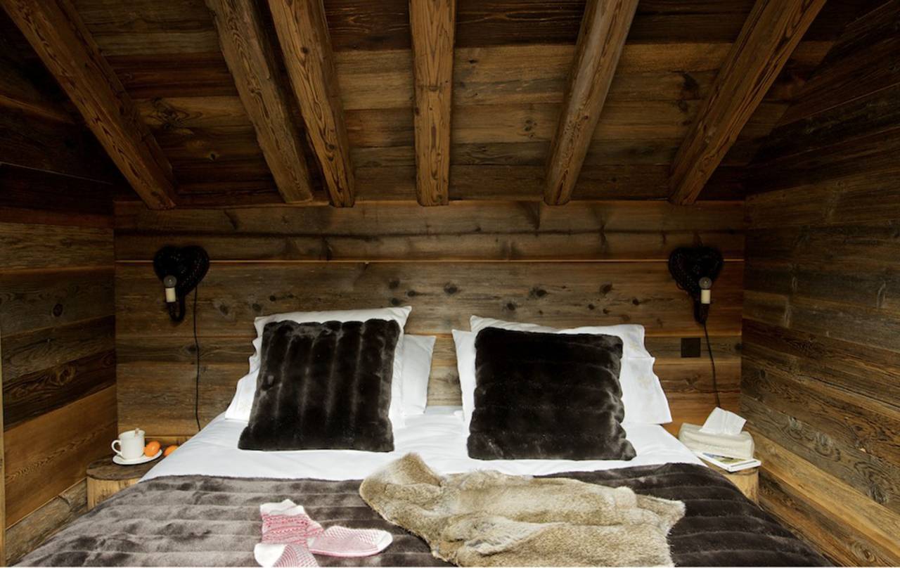 Szőrme és ágytakaró a faház hálószobájában