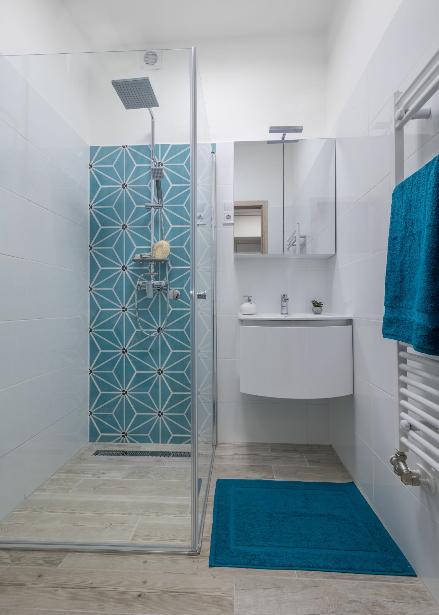 Fahatású lapok és türkiz geometrikus lapok adnak friss és modern hangulatot a fürdőszobának