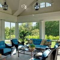 Üvegezett veranda fonott bútorok és kék ülőpárnák