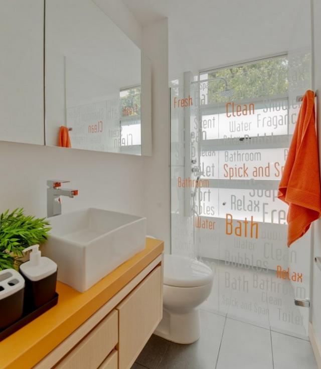 Fehér fürdőszoba narancs dekorációval