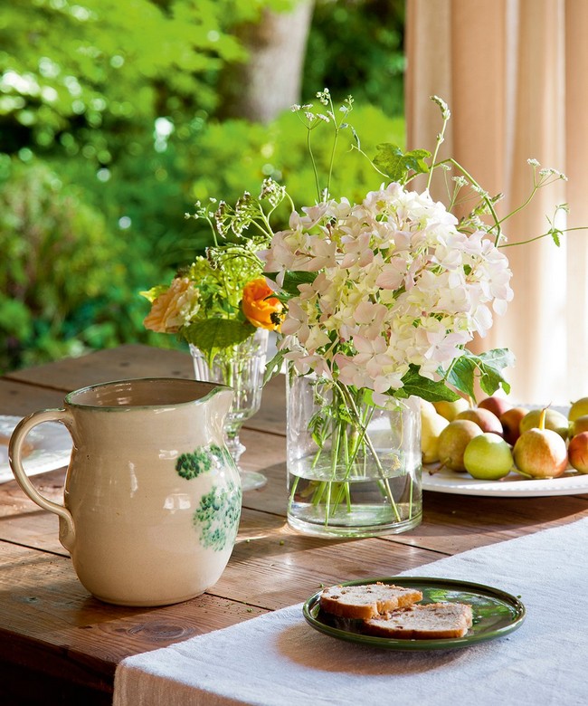 Asztaldekoráció kerámia kancsóval és virágokkal