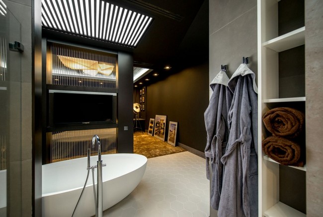 Térben álló fürdőkád egy sötétbarna nappalival