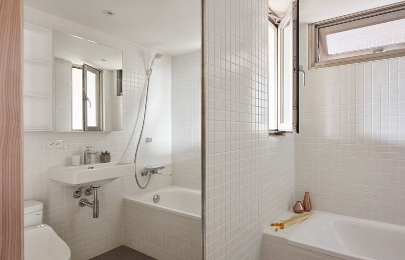 Fehér fürdőszoba letisztult egyszerűséggel mozaik burkolattal