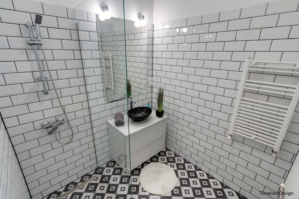 Modern szellős fürdőszoba fehér metró csempével, de sötét színű fugával