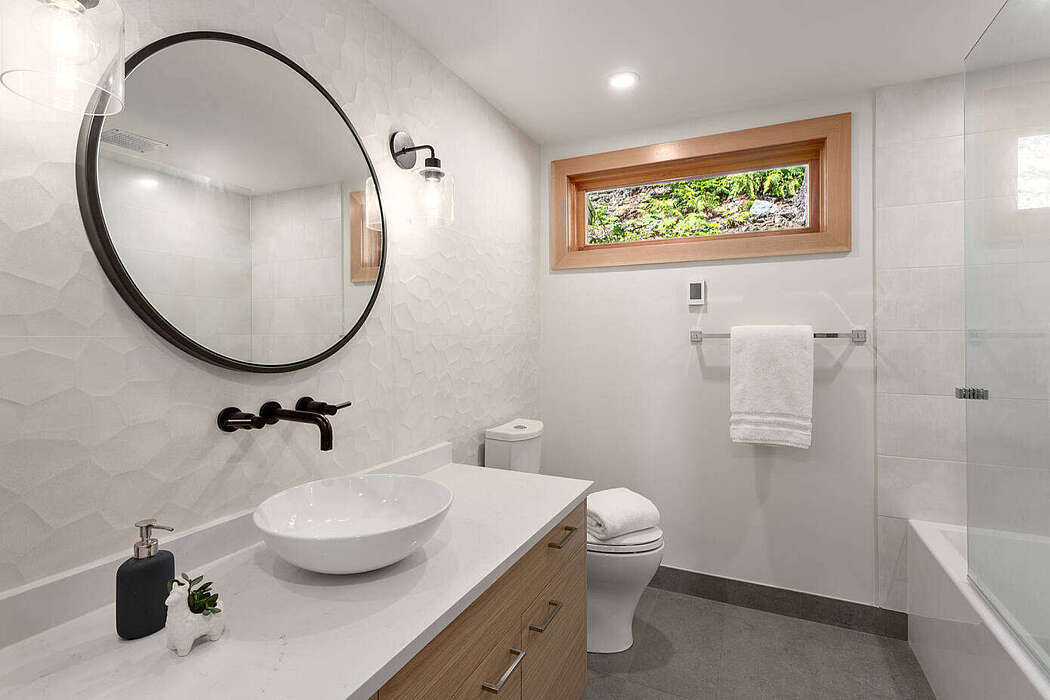 Modern fürdőszoba kerek tükörrel betonszürke padlólappal