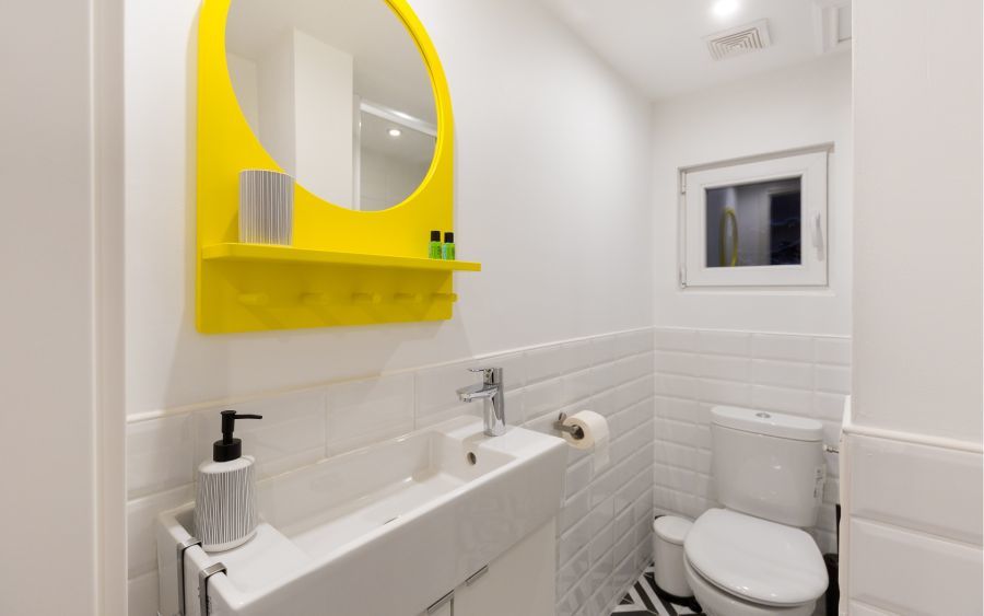 Airbnb fürdőszoba sárga tükörrel