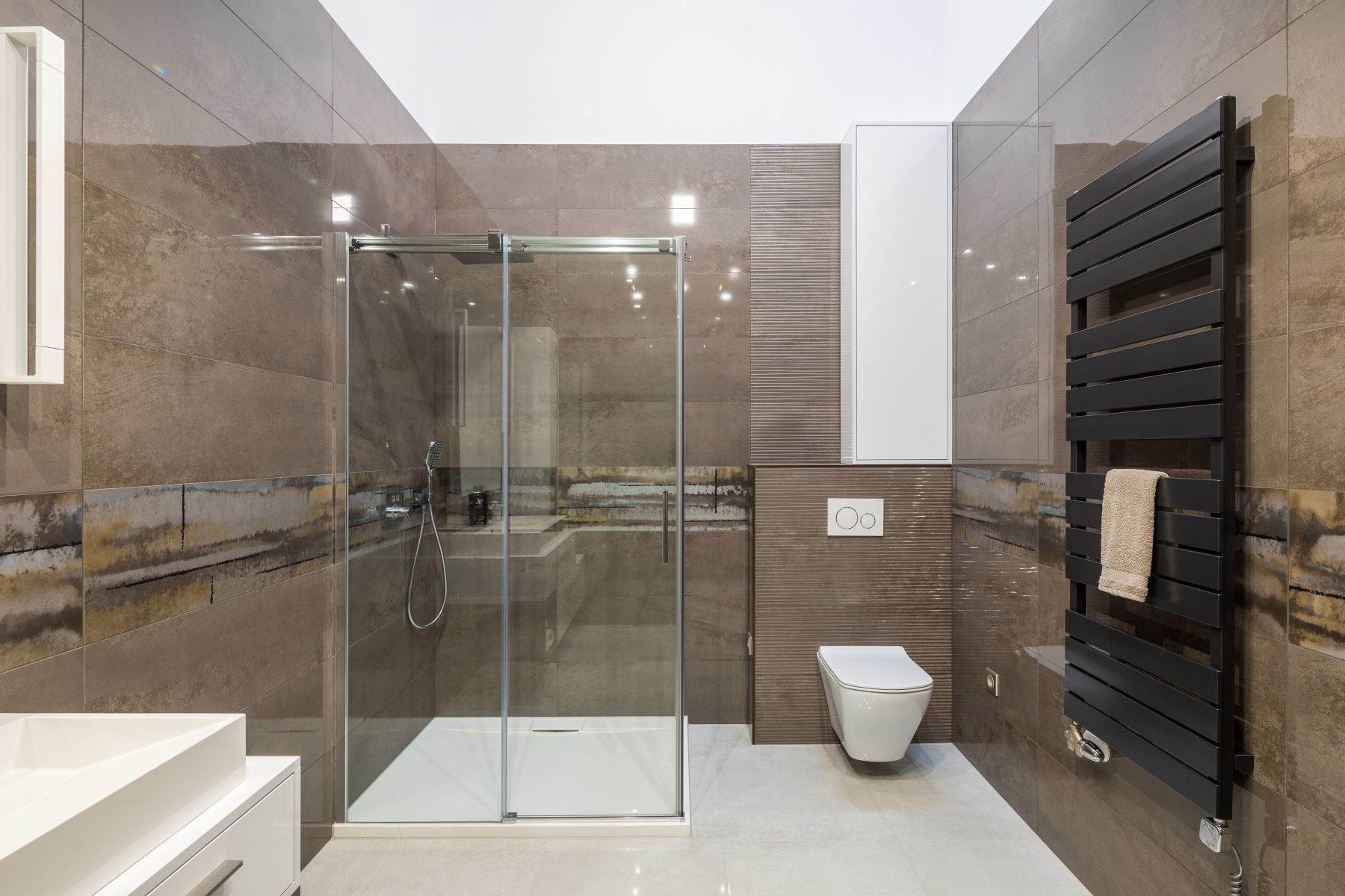 Modern zuhanyzós fürdőszoba barna és világos burkolatokkal
