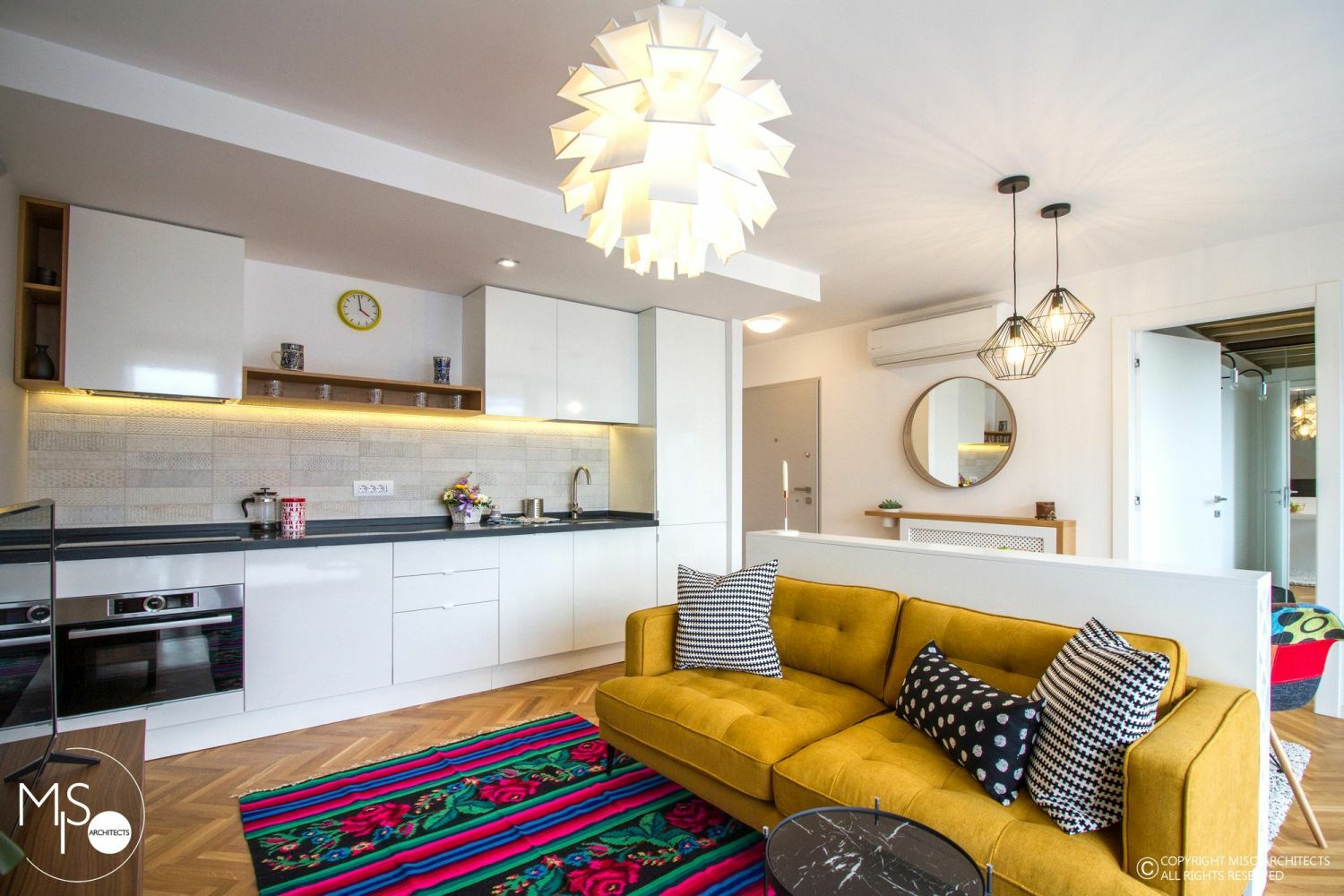 Multifunkciós tér fehér konyhával, sárga kanapéval színek szőnyeggel