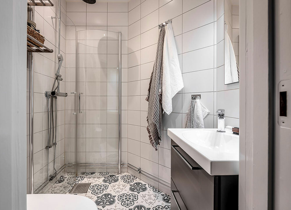 Visszafogott fürdőszoba design mintás padló és fehér csempe