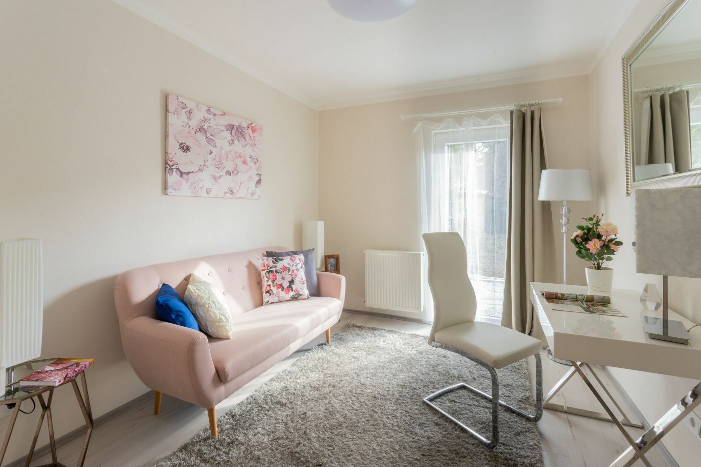 A kis szoba berendezése rózsaszínű kanapéval és íróasztallal
