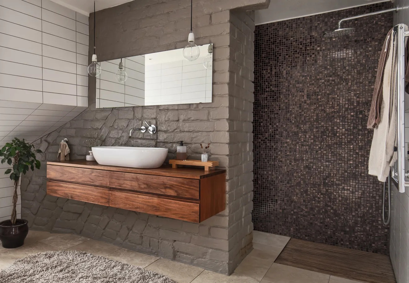 Mozaikburkolatos zuhanyzó és az eredeti téglafalra szerelt fürdőszobabútor