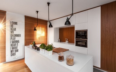 Magasfényű fehér konyhabútor és firkálható étkezőfal sok fafelületetel