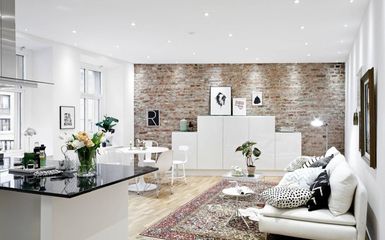 Látszó téglafal és sok fehér bútor egy svéd polgári lakásban 