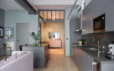Loft jellegű lakás matt szürke konyhával halványzöld falszínnel
