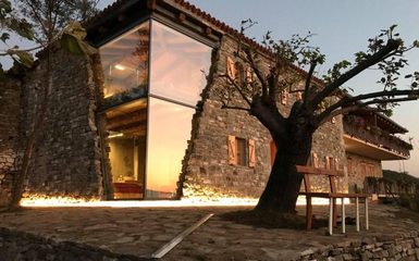 Üvegtáblákban folytatódik a régi kőház fala egy albániai szálláshelyen
