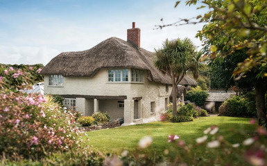 Öreg angol nádfedeles ház szép kerttel és új trendek szerinti natúr lakberendezéssel