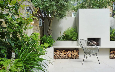 Felújított modern londoni hátsó kert tűzrakóval és levendulákkal